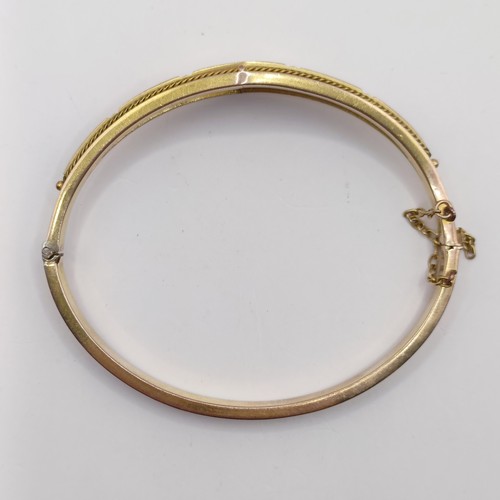 688 - A late 19th century yellow coloured metal, ruby and diamond bangle