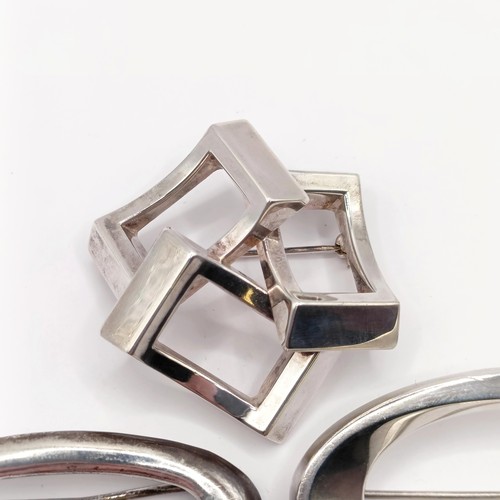 691 - A silver coloured metal abstract brooch, and two other brooches (3)