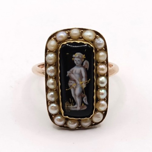 701 - A mourning ring, with black enamel plaque, decorated putti, surrounded by seed pearls, ring size N