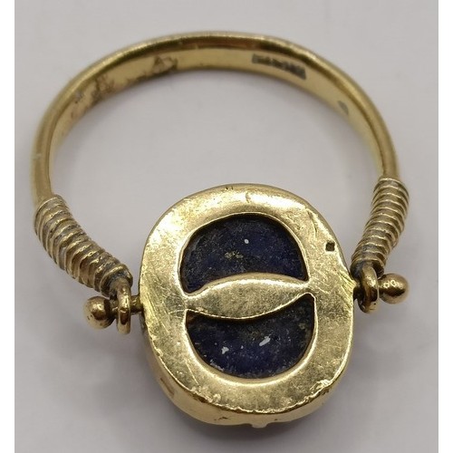 711 - A gold and carved blue stone Egyptian style ring, blue stone carved in the form of a scarab, ring si... 