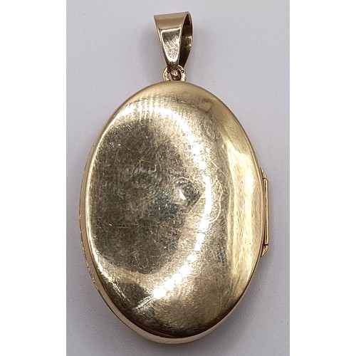 724 - A yellow metal and blue stone oval locket, 7.7 g (all in)