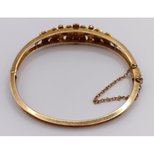 726 - A 15ct gold, seed pearl and diamond bangle, 14.9 g (all in)