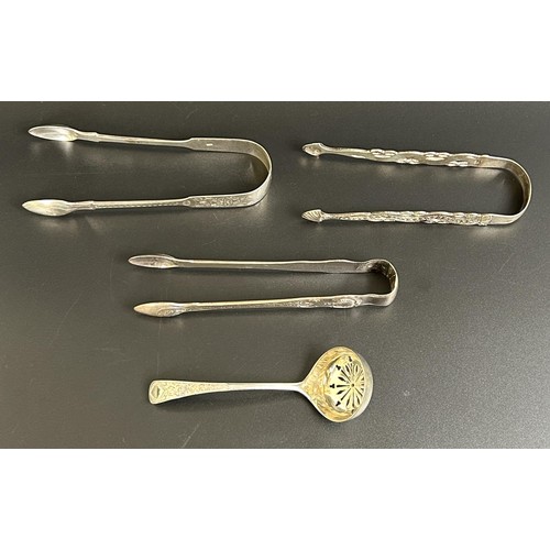 126 - A pair of Victorian sugar tongs, another pair of sugar tongs and a sifting spoon, various dates and ... 