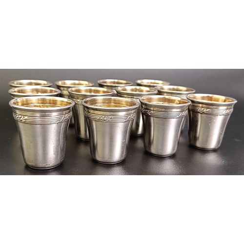 141 - A set of twelve Continental silver coloured metal shot cups, 107 g, cased