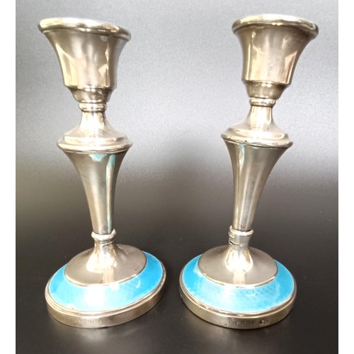 159 - A pair of George V silver and blue enamel candlesticks, bases filled, 14 cm high, and assorted silve... 