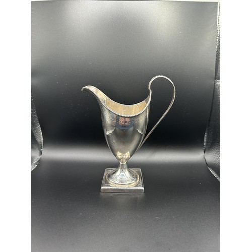 350 - A George III silver jug, with bright cut decoration, crested, London 1789, 2.3 ozt, 13 cm high