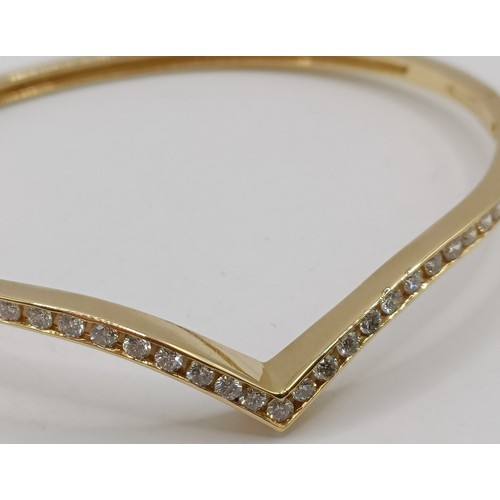 652 - An 18ct gold and diamond wishbone bangle, 11.6 g (all in)