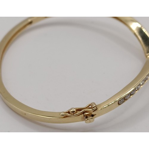 652 - An 18ct gold and diamond wishbone bangle, 11.6 g (all in)