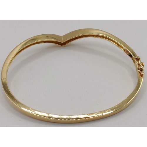 652 - An 18ct gold and diamond wishbone bangle, 11.6 g (all in)