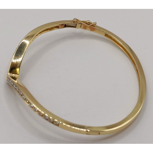 652 - An 18ct gold and diamond wishbone bangle, 11.6 g (all in)