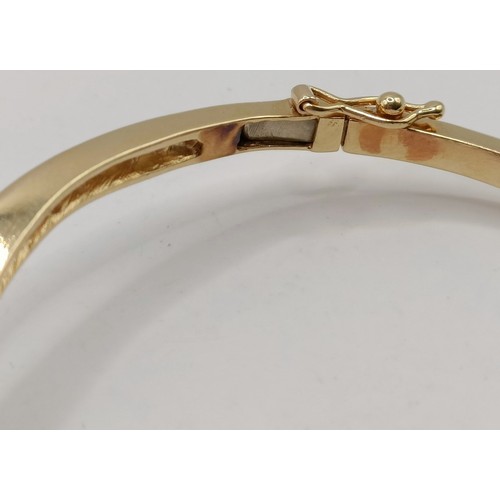 652 - An 18ct gold and diamond wishbone bangle, 11.6 g (all in)