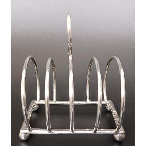 263 - A George V cream jug, a four section silver toast rack, a pair of sugar nips and a fish knife, vario... 