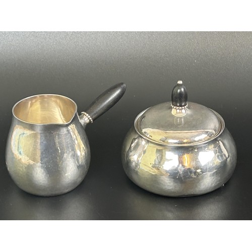 415 - A Georg Jensen Classic Art Nouveau silver three piece coffee service, with hammered decoration and e... 