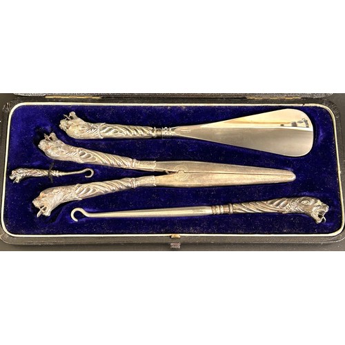 306 - A Cartier style dressing set, with silver tiger's head mounts, cased