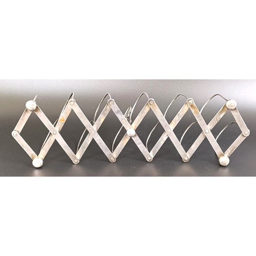 251 - A silver coloured metal collapsible toast rack, 10.5 cm wide