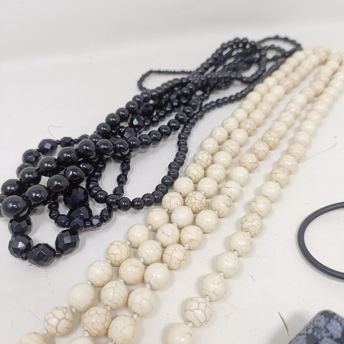 834 - A pale stone bead necklace, a set of four matching carved stone pendants, and two black bead necklac... 