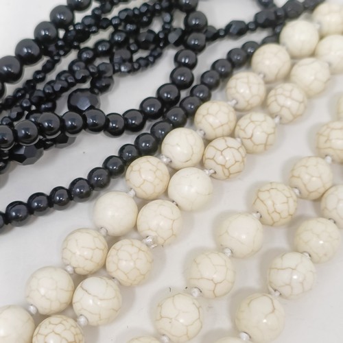 834 - A pale stone bead necklace, a set of four matching carved stone pendants, and two black bead necklac... 