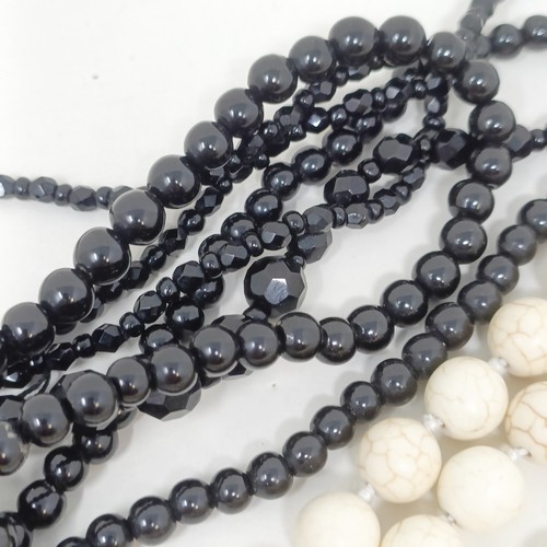 834 - A pale stone bead necklace, a set of four matching carved stone pendants, and two black bead necklac... 