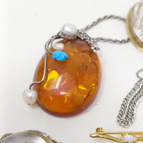 833 - An amber and silver coloured metal pendant on a chain, and assorted other costume jewellery