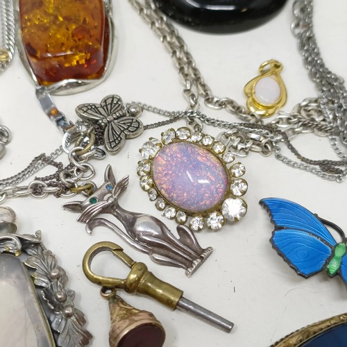 833 - An amber and silver coloured metal pendant on a chain, and assorted other costume jewellery