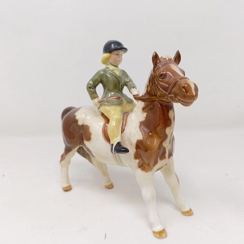 1002 - A Beswick Boy's Pony, palomino, 1500, and a Girl's Pony, skewbald, 1499, (chip to hoof), both g... 