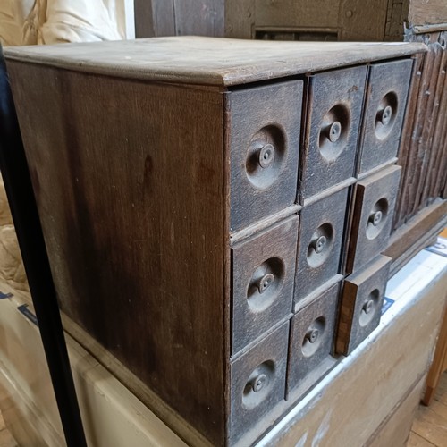 1224 - An oak chest, having nine drawers, 38 cm wide