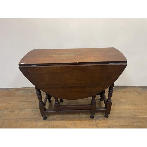 1204 - An oak monk's bench, 110 cm wide, a dresser, a drop leaf table, a radio, a waterfall bookcase, and a... 