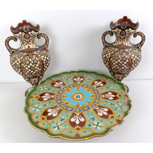 1061 - A Minton style tazza, various losses, 45 cm wide, and a pair of Continental vases, 40 cm high (3)