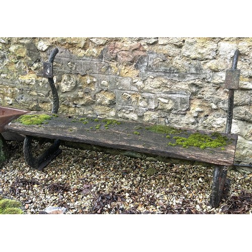 1356 - A garden bench, with cast iron ends in the form of snakes, 133 cm wide, seat heavily weathered, lack... 