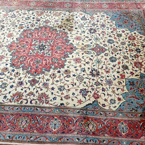 1350 - A Persian cream ground carpet, centre with repeating foliate forms and a main red border, 310 x 200 ... 