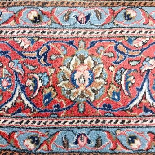 1350 - A Persian cream ground carpet, centre with repeating foliate forms and a main red border, 310 x 200 ... 