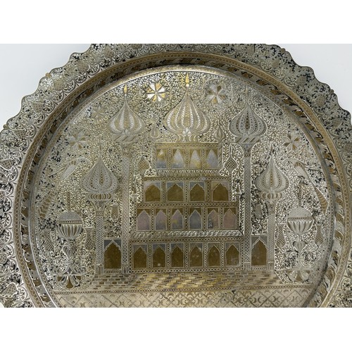 1101 - An Islamic brass tray, with silver coloured metal inlay, decorated building, 39 cm diameter