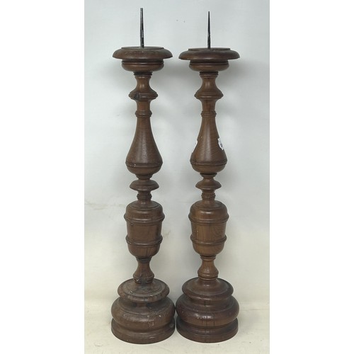 1102 - A pair of turned wooden candlesticks, 48 cm high (2)