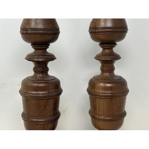 1102 - A pair of turned wooden candlesticks, 48 cm high (2)