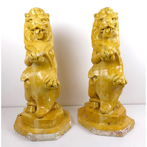 1115 - A pair of yellow glazed lion finials, various losses, 63 cm high (2)