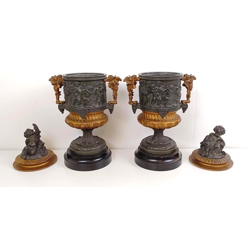 1080 - A pair of brass and bronze urns, with covers, with cherub finials on wooden bases, 40 cm high (2)