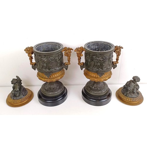 1080 - A pair of brass and bronze urns, with covers, with cherub finials on wooden bases, 40 cm high (2)