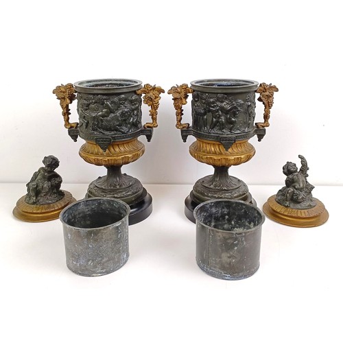 1080 - A pair of brass and bronze urns, with covers, with cherub finials on wooden bases, 40 cm high (2)