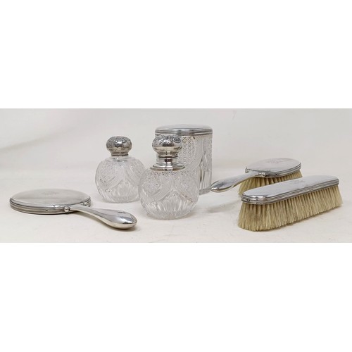 419 - A Danish silver coloured metal part dressing table set, comprising a hand mirror, two brushes, a sil... 