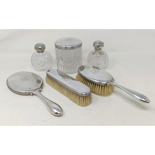 419 - A Danish silver coloured metal part dressing table set, comprising a hand mirror, two brushes, a sil...