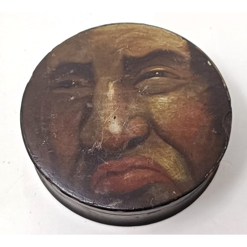 1027 - A 19th century papier mache snuff box, the lid painted with face of a grotesque man, 11 cm diameter