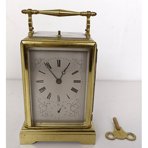 842 - A French carriage clock, with repeast, the silvered dial with alarm dial, in a brass four pillar cas... 