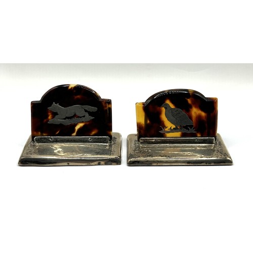 1018 - A pair of silver and tortoiseshell menu holders, decorated a running fox and a grouse (2)