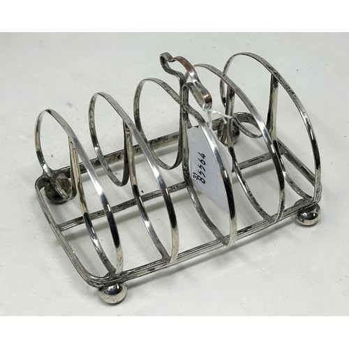 1022 - A spelter figure of a lion, 14.5 cm high, a 19th century plated on copper toast rack, and a similar ... 