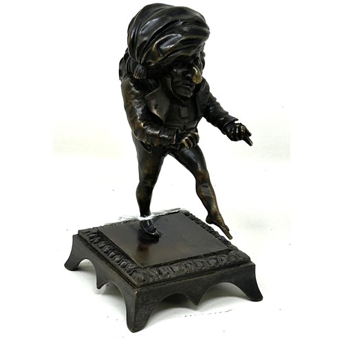 1023 - A bronze caricature figure, on a square base, possibly a hat pin stand, 13 cm high