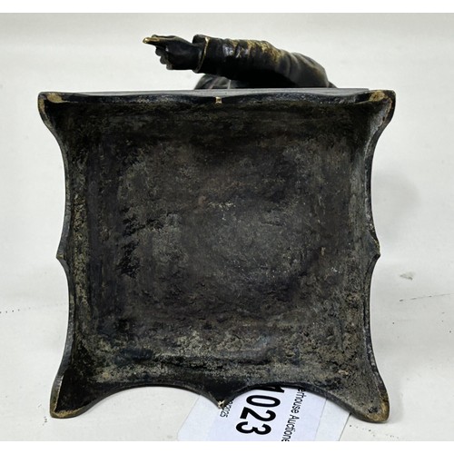 1023 - A bronze caricature figure, on a square base, possibly a hat pin stand, 13 cm high