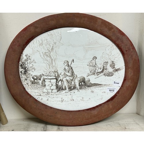 1012 - A late 19th century oval pottery plaque, decorated figures and animals by fires, signed Violet Littl... 