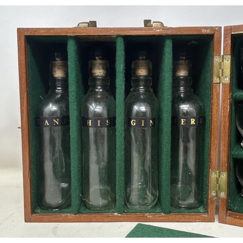 1144 - An early 20th century mahogany travelling tantalus, with four original bottles, and twelve non match... 