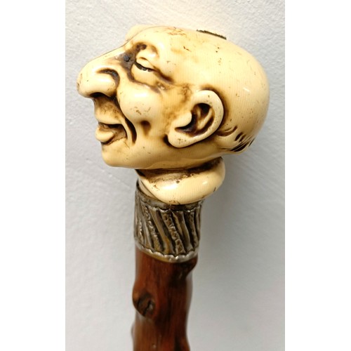 1126 - A novelty walking stick, with a molded handle, in the form of a laughing man, with a silver collar, ... 