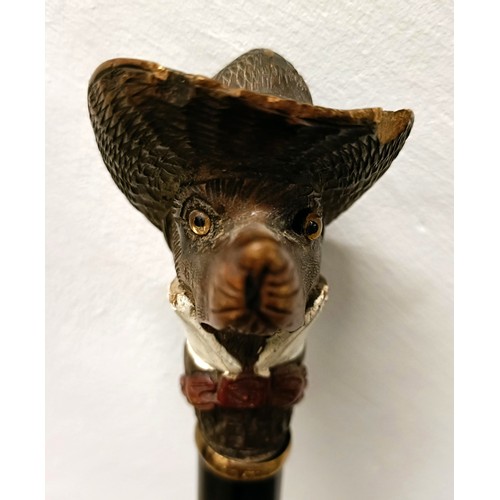 1136 - A novelty walking stick, handle carved in the form of a dog's head wearing a Stetson, with a yellow ... 